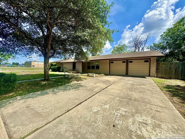 single story home featuring a garage and a front lawn