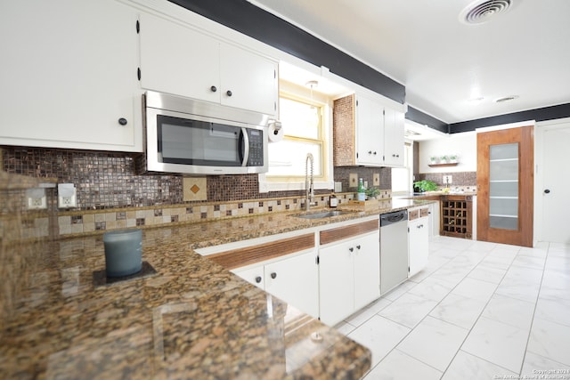 kitchen featuring white cabinetry, stainless steel appliances, backsplash, and sink