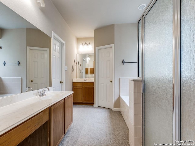 full bathroom featuring a garden tub, two vanities, a sink, and a stall shower