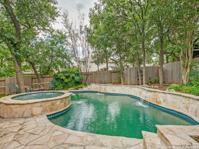 view of pool with an in ground hot tub and pool water feature