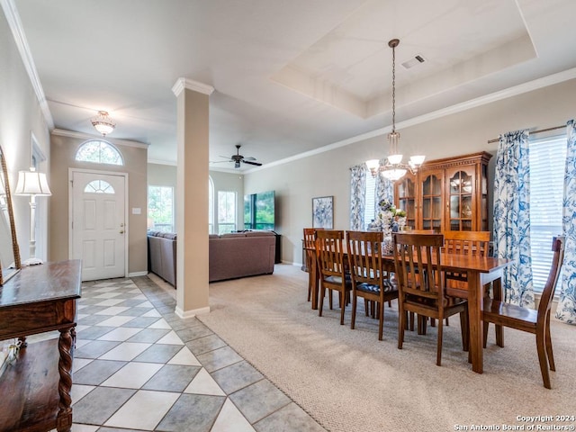 dining area with a tray ceiling, visible vents, light carpet, baseboards, and ceiling fan with notable chandelier