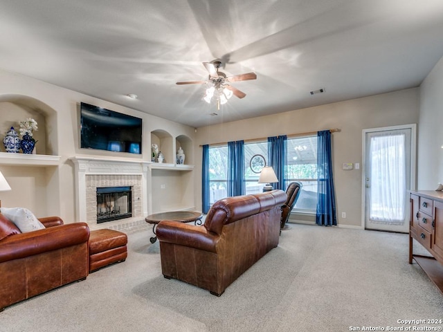 carpeted living room with built in features, a fireplace, visible vents, ceiling fan, and baseboards