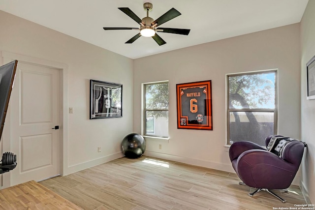 living area with ceiling fan and light hardwood / wood-style floors