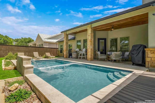 view of swimming pool featuring pool water feature, a patio, and ceiling fan