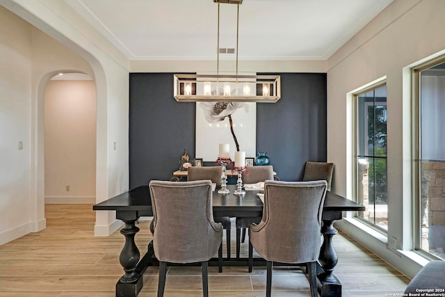 dining room with light hardwood / wood-style flooring, crown molding, and a chandelier