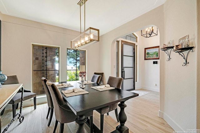 dining space featuring light hardwood / wood-style flooring and an inviting chandelier