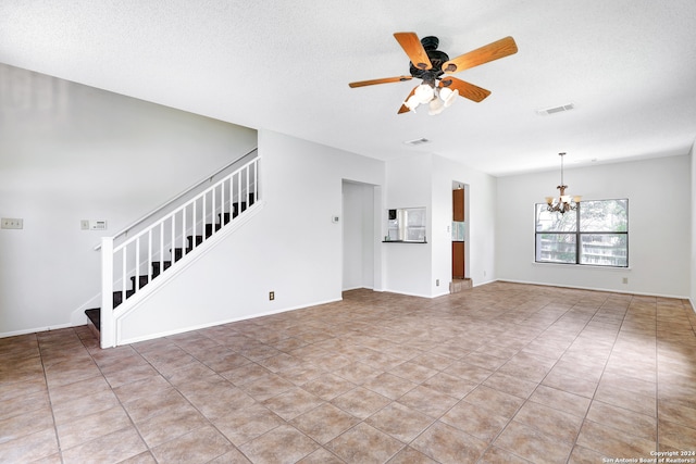 unfurnished living room featuring light tile patterned flooring, ceiling fan with notable chandelier, and a textured ceiling