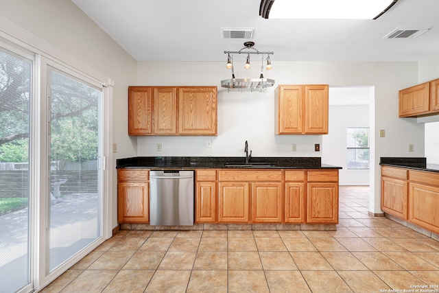 kitchen with a wealth of natural light, light tile patterned floors, and stainless steel dishwasher