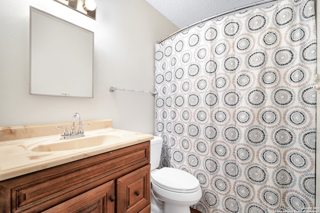 bathroom with vanity, toilet, and a textured ceiling