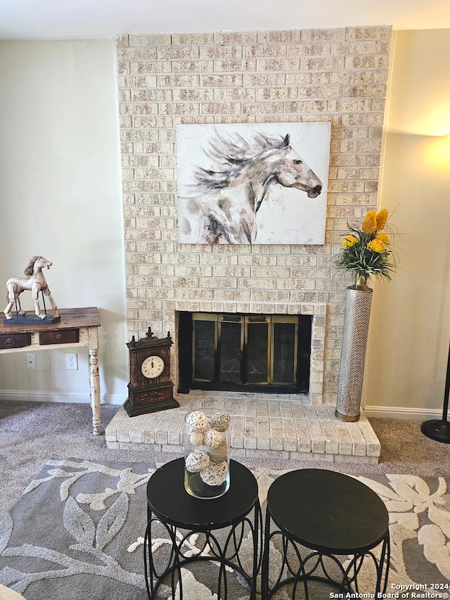 living room with brick wall, a fireplace, and carpet flooring