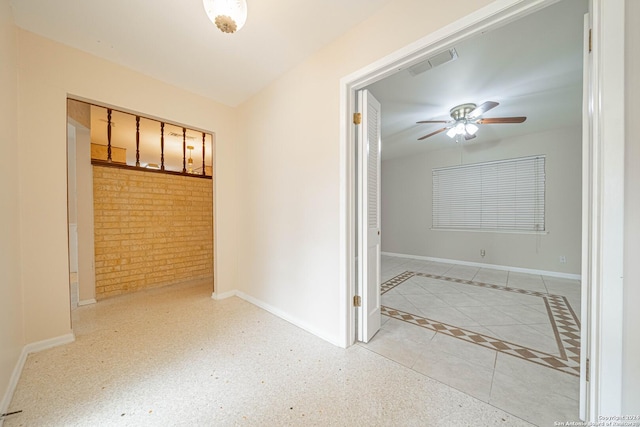 unfurnished bedroom with brick wall and ceiling fan