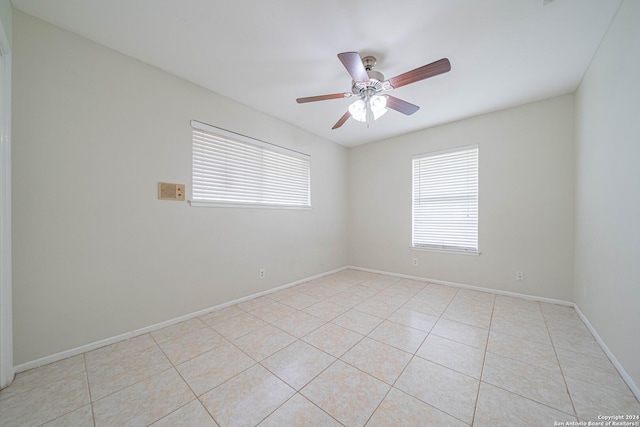 tiled spare room with ceiling fan