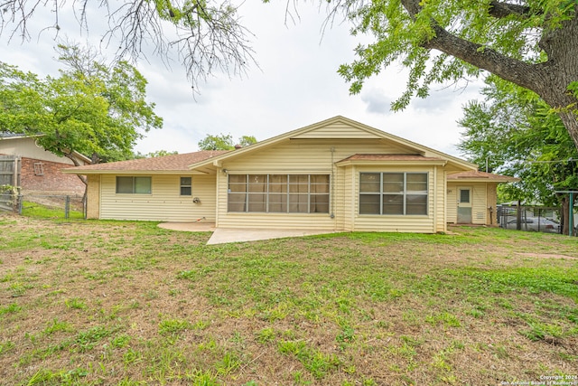 back of property featuring a patio and a lawn