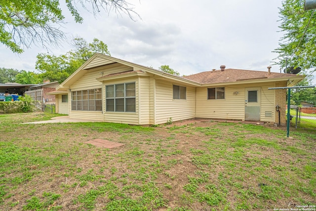 rear view of property with a yard