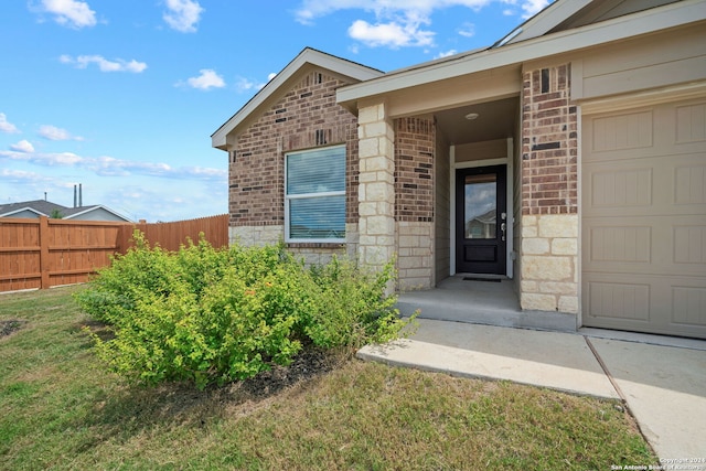 property entrance with a garage and a yard