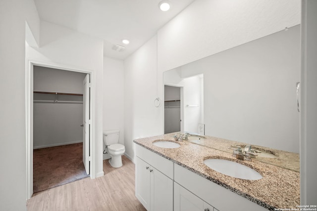 bathroom with dual vanity, hardwood / wood-style flooring, and toilet