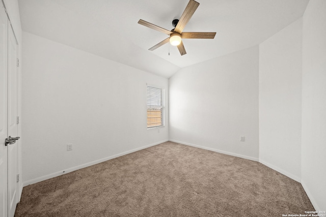 carpeted empty room featuring ceiling fan and vaulted ceiling