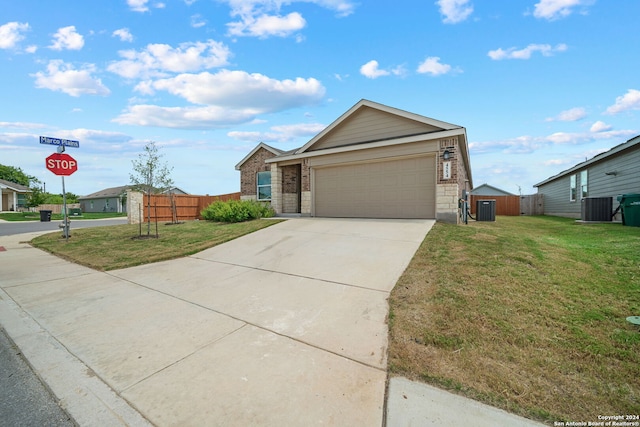 view of front of house featuring a garage, cooling unit, and a front yard