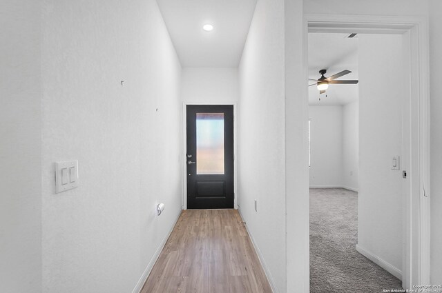 unfurnished living room featuring vaulted ceiling, light hardwood / wood-style flooring, ceiling fan, and plenty of natural light