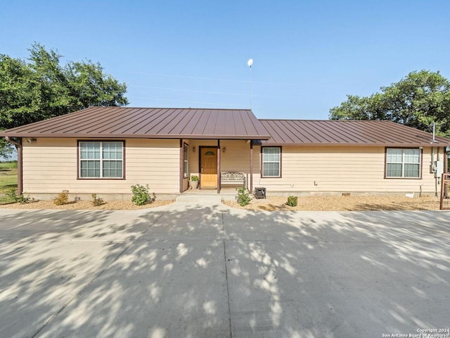 single story home featuring covered porch, metal roof, crawl space, and a standing seam roof