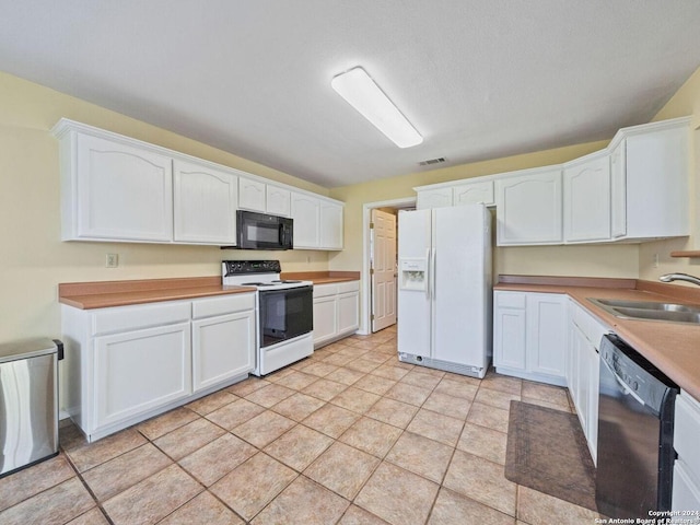 kitchen with black appliances, visible vents, white cabinets, and a sink
