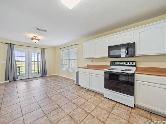 kitchen with light tile patterned flooring, white range with electric stovetop, white cabinets, and french doors