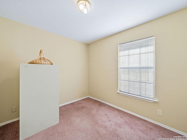 unfurnished room featuring carpet flooring and baseboards