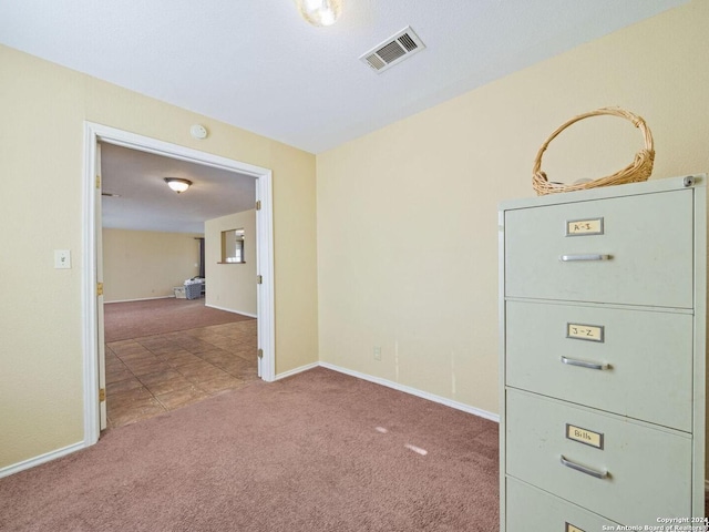 carpeted spare room with visible vents and baseboards