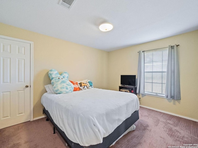 carpeted bedroom featuring visible vents and baseboards