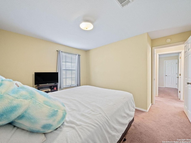bedroom with light colored carpet, visible vents, and baseboards