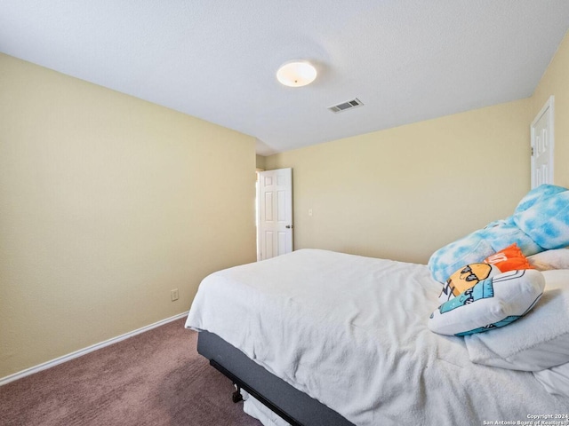 carpeted bedroom with visible vents and baseboards