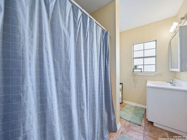 full bath with curtained shower, tile patterned flooring, vanity, and baseboards