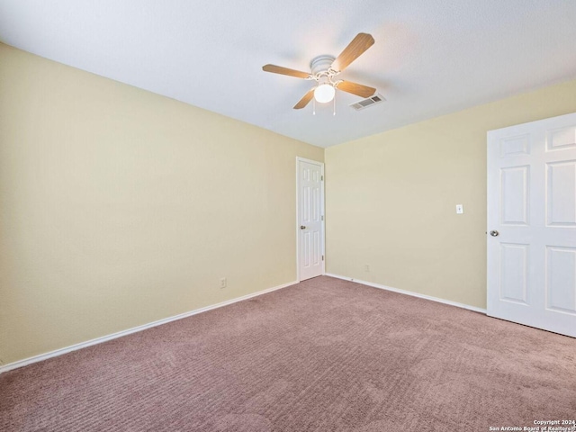 spare room featuring a ceiling fan, carpet, visible vents, and baseboards