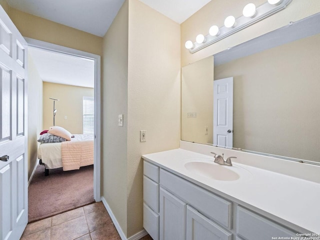 bathroom featuring connected bathroom, tile patterned flooring, vanity, and baseboards