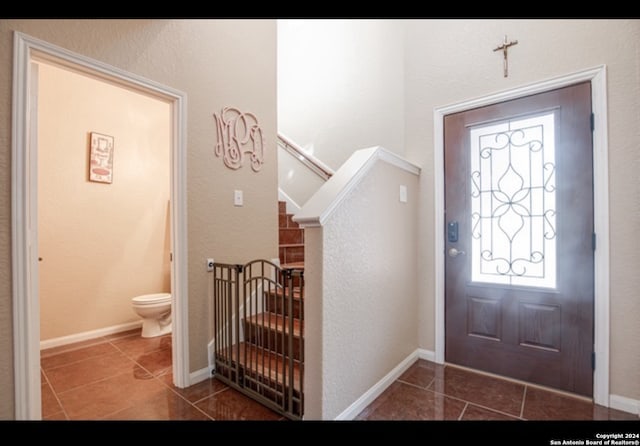 foyer featuring dark tile patterned floors