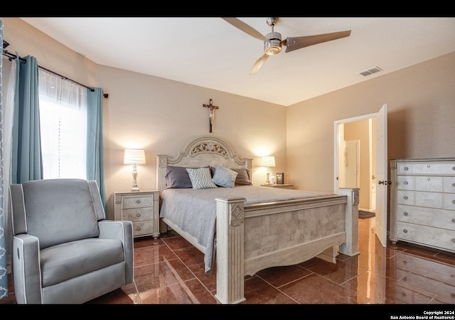 tiled bedroom featuring ceiling fan