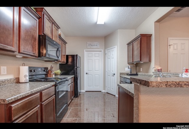 kitchen with a textured ceiling, kitchen peninsula, black appliances, and light tile patterned floors