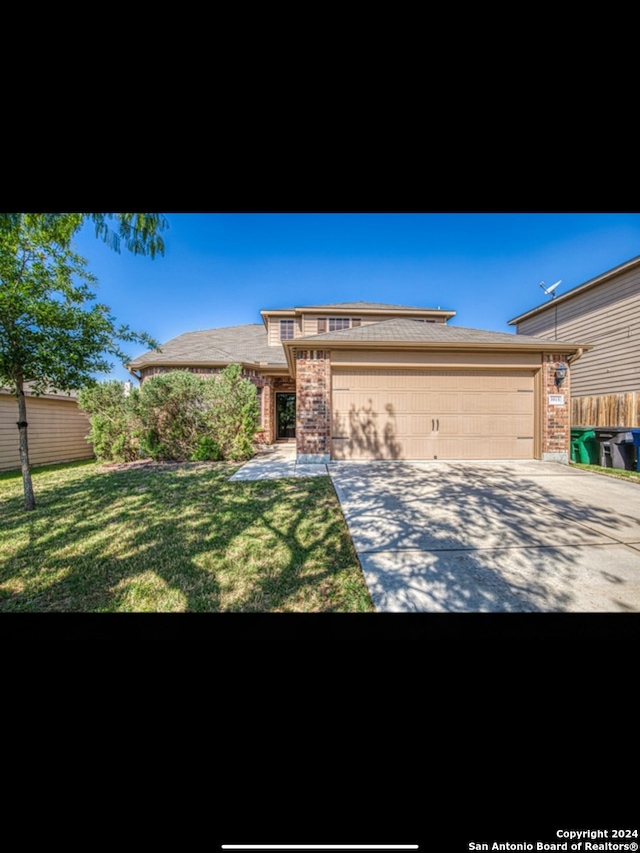 prairie-style home featuring a garage and a front lawn