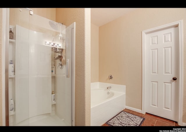 bathroom with independent shower and bath and tile patterned flooring