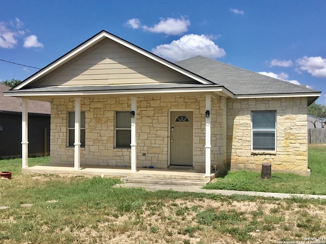 view of front of home with covered porch and a front lawn