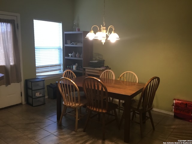 dining space featuring a chandelier and dark tile patterned floors