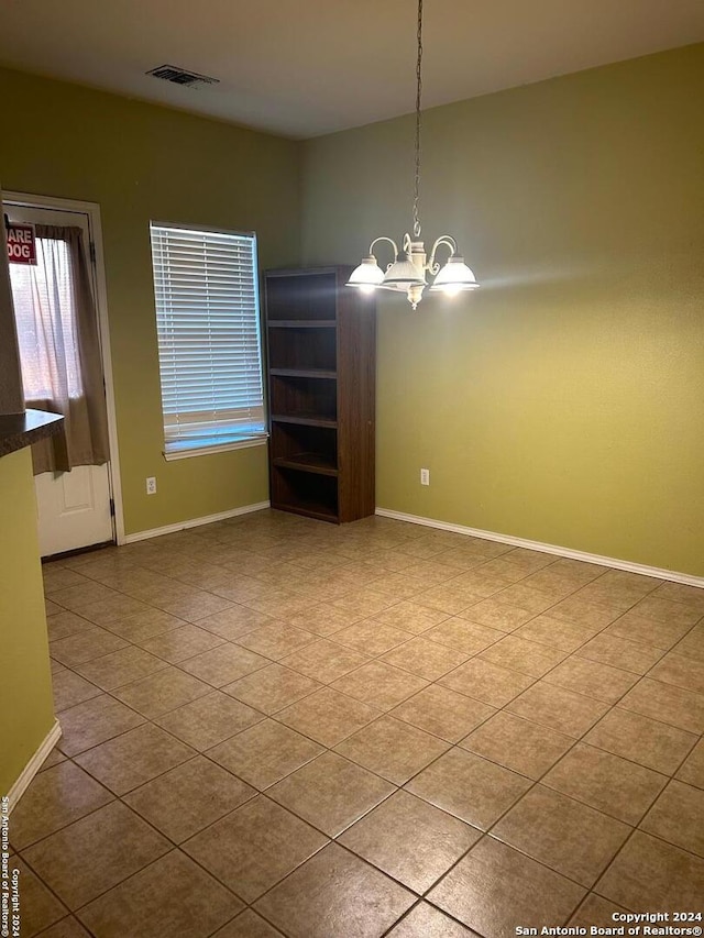 unfurnished dining area featuring an inviting chandelier