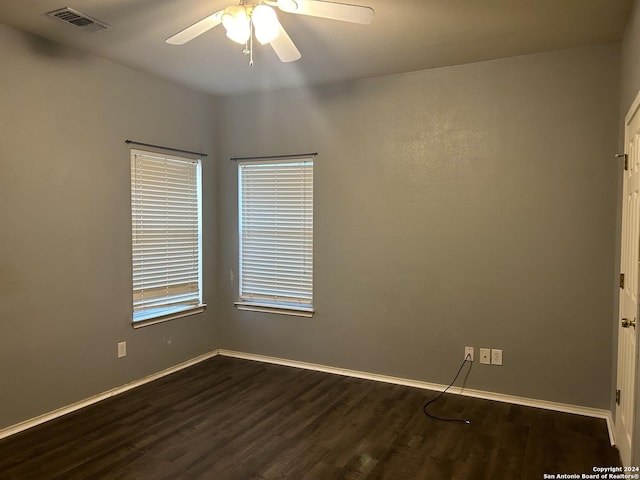 spare room with ceiling fan and dark hardwood / wood-style floors