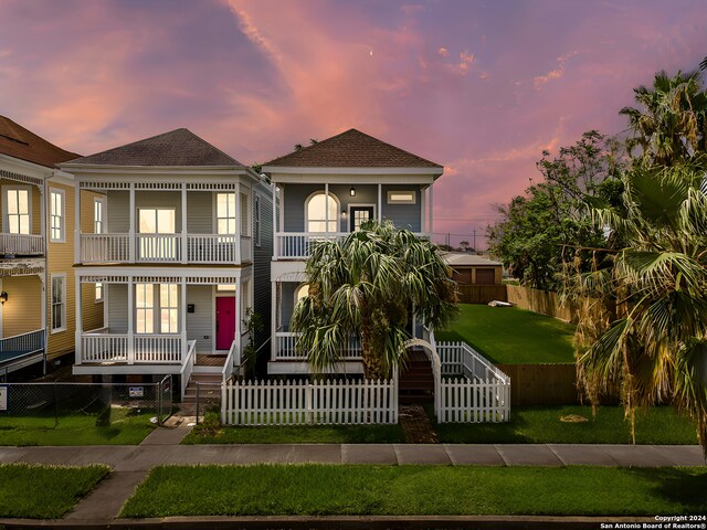 view of front facade featuring a balcony and a front lawn