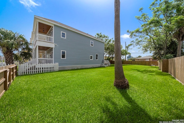 rear view of property with a balcony and a lawn