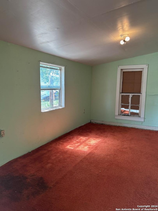 spare room featuring lofted ceiling and carpet flooring