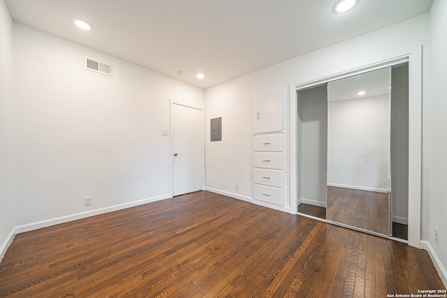 unfurnished bedroom featuring dark wood-type flooring and electric panel