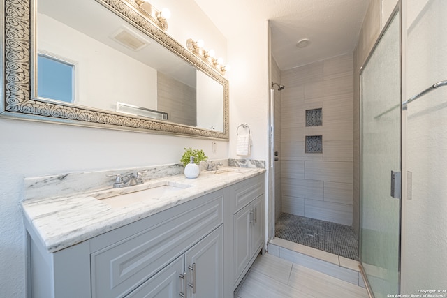 bathroom featuring tile patterned flooring, vanity, and a shower with shower door