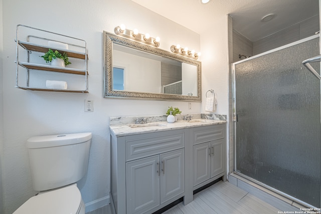 bathroom with vanity, toilet, and an enclosed shower