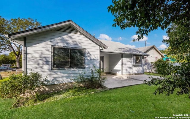 back of property with a yard and a patio